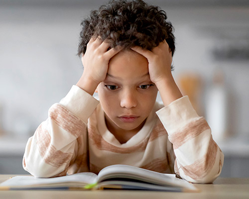 DEVELOPMENTAL DELAYS Little boy trying to read